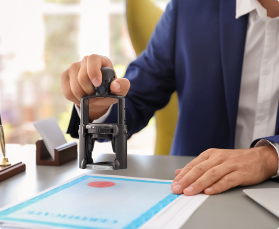 A man stamps an accreditation seal on a certificate