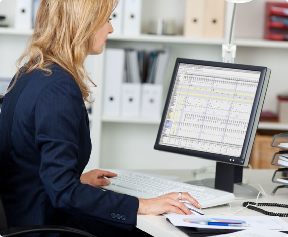 Ergonomics-Sessions-img-1 An employee works on a spreadsheet seated at an ergonomic desk