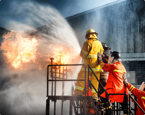 Firefighters spray their hose at a fire