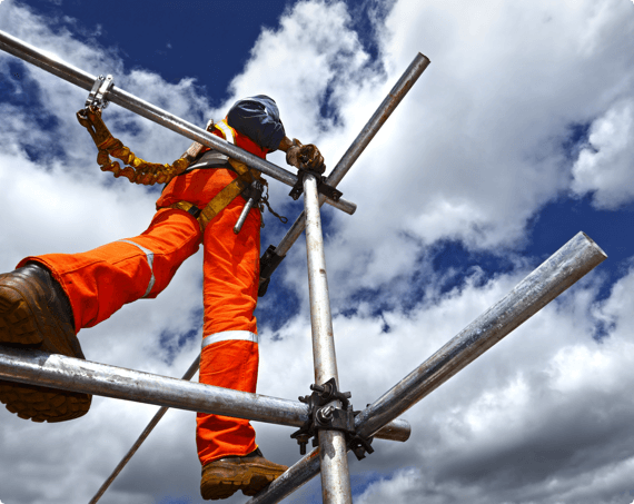A construction worker walks on scaffolding