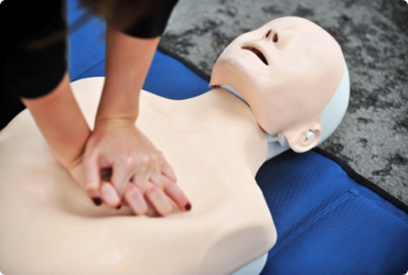 An employee practices CPR on a dummy