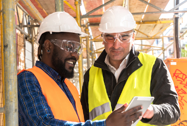 Members of a joint health and safety committee smile as they review safety procedures onsite