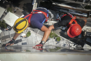 two workers are suspended as they work outside of a high rise building 