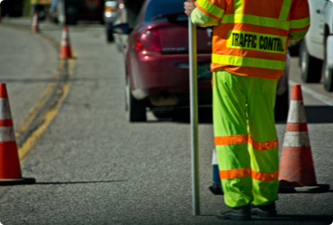 A worker controls traffic on a road during construction