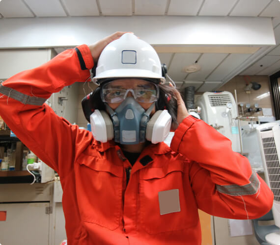 Respirator Protection Training An environmental inspector with goggles and a helmet puts on a respirator