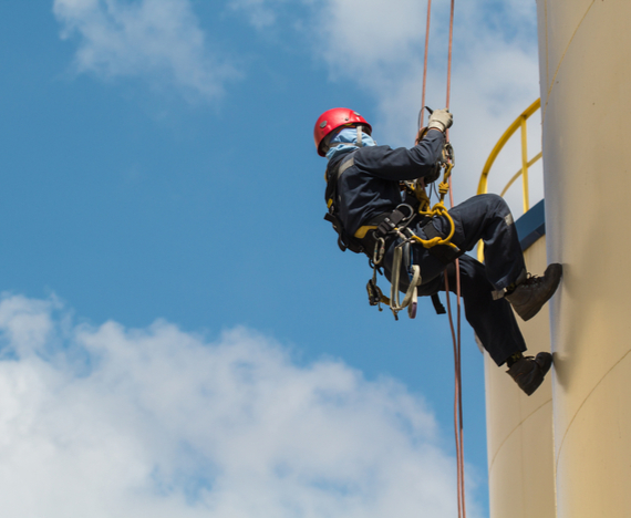 working at heights a train construction worker properly equipped with fall safety gear