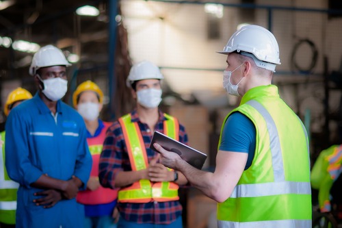 team leader helps workers with training
